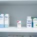 Étagère de pharmacie avec un emplacement vide et plusieurs produits de santé alternatifs non identifiés.