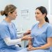 Illustration médicale sobre montrant une chirurgienne examinant avec bienveillance une femme adulte lors d’une consultation postopératoire dans un cabinet clinique rassurant.