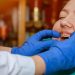 Orthodontiste plaçant un disjoncteur palatin dans la bouche d’un jeune patient.